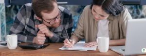 Parents reviewing financial aid paperwork together at the kitchen table