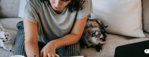 Student writing a personal essay at home in a notebook